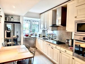 a kitchen with white cabinets and a wooden table at Orchid Luxury Suite Croisette Sea View Terrace 2 Bedr in Cannes