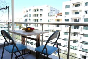 einen Tisch mit Stühlen und eine Obstschale auf dem Balkon in der Unterkunft Merry's Apartment in Durrës