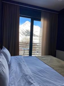 una camera con letto e vista sulle montagne di Hilltop Kazbegi a Kazbegi