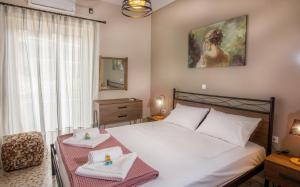 a bedroom with a bed with a table with two towels at 3SSS Bouquet Studios SERENITY in Marmari
