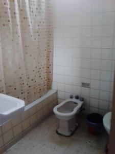 y baño con aseo y cortina de ducha. en HOSTEL JUJUY en San Salvador de Jujuy