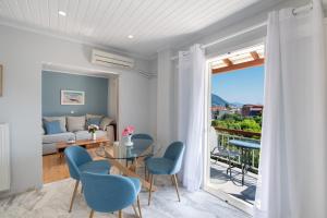 a living room with a glass table and blue chairs at chris apartement in Nydri