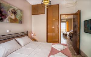 a bedroom with a bed and a painting on the wall at 3SSS Bouquet Studios SERENITY in Marmari