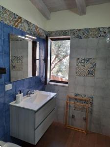 bagno con lavandino e finestra di Villetta del Poggio a Marina di Camerota