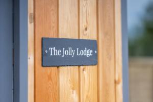 a sign that reads the jolly lodge on a wooden door at The Jolly Lodge-Sea Views-Free Parking in Lyme Regis