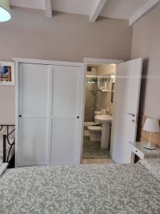 um quarto branco com uma cama e uma casa de banho em Bed and Breakfast Federica em Noto