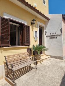 a wooden bench sitting outside of a building at Bed and Breakfast Federica in Noto