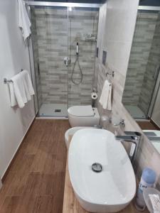 a bathroom with a toilet and a sink and a shower at Bed and Breakfast Federica in Noto