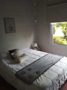 Schlafzimmer mit einem weißen Bett und einem Fenster in der Unterkunft los agapantus in Ingeniero Maschwitz