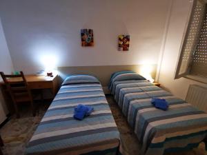 2 posti letto in una camera con asciugamani blu di Casa Serena a Bordighera