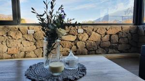 a vase with flowers and a candle on a table at Casa de Piedra in Zonda