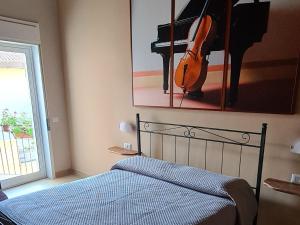 a bedroom with a bed with a violin and a piano at SINFONIA SUITES CATANIA in Catania