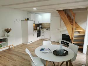 eine Küche und ein Esszimmer mit einem weißen Tisch und Stühlen in der Unterkunft Appartementhaus 10 Seen in Waren (Müritz)