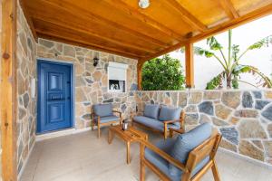 un patio con una puerta azul y sillas en una pared de piedra en Summer Private Villa with Garden and Private Pool, Within Walking Distance to the Sea in Bodrum Gumusluk, en Bodrum City