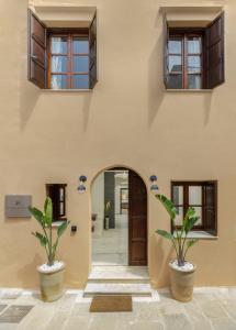 an entrance to a building with two potted plants at Kamares Boutique Residence in Rethymno Town