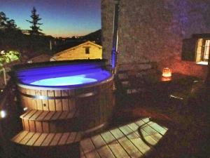 a hot tub sitting on a balcony at night at Maison en Pierre in Fiastra
