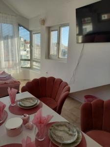 a living room with a table and chairs and a television at Perla 2 studio in Burgas City