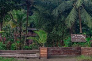a wooden bench in front of a lush green forest at The Pelican House Hostel in El Valle