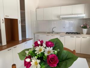 a bouquet of flowers sitting on a table in a kitchen at Gallipoli Mancaversa Futura Vacanza Andrea in Marina di Mancaversa