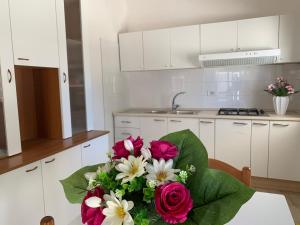 a bouquet of flowers on a table in a kitchen at Gallipoli Mancaversa Futura Vacanza Andrea in Marina di Mancaversa