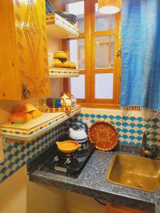 un bancone della cucina con piano cottura e lavandino di Riad Milal a Essaouira