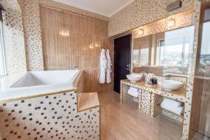 
a bathroom with a tub, sink, and bathtub at Hotel Hafnia in Tórshavn
