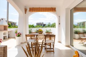 uma sala de jantar com uma mesa e cadeiras numa varanda em casa vacanze La Dolce sosta em Lotzorai