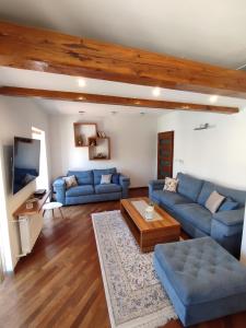 a living room with blue couches and a tv at Deluxe Apartment Lejla - Free garage parking in Sarajevo