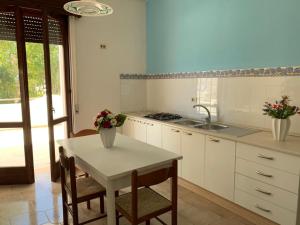 a kitchen with a table and chairs and a sink at Gallipoli Mancaversa Futura Vacanza Andrea in Marina di Mancaversa