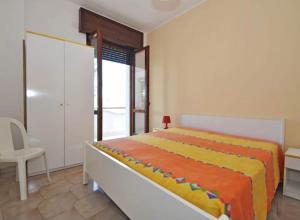 a bedroom with a bed with an orange and yellow blanket at Gallipoli Mancaversa Futura Vacanza Andrea in Marina di Mancaversa