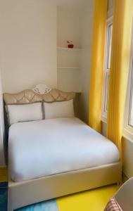 Cama blanca en habitación con ventana en Ziggla Luxury Properties en Londres