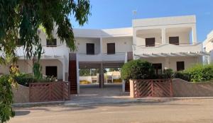 a white building with a gate in front of it at Gallipoli Mancaversa Futura Vacanza Andrea in Marina di Mancaversa