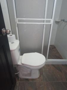 La salle de bains est pourvue d'une douche et de toilettes. dans l'établissement Los Recuerdos de Florito y Leo, à Monguí