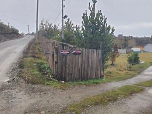 una valla de madera al lado de una carretera en Cabaña Nothofagus PUQ, en Punta Arenas