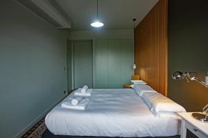 Habitación con 3 camas y toallas blancas. en Luxury apartment near Fonte Luminosa en Lisboa