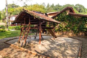 ein Haus mit Holzkonstruktion und Leiter in der Unterkunft HOTELARE Hotel Villa Di Capri in Ubatuba