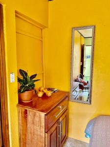 a yellow room with a mirror and a wooden dresser at Apartamentos M&M in Fortuna
