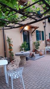 patio ze stołem i krzesłami oraz budynek w obiekcie Agriturismo Alveare w mieście Finale Ligure