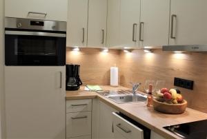a kitchen with a sink and a bowl of fruit on a counter at Ferienwohnung Bergflora in Oberstdorf