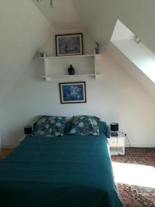 a bedroom with a green bed with two pillows at Ty Biz in Saint-Jean-Trolimon