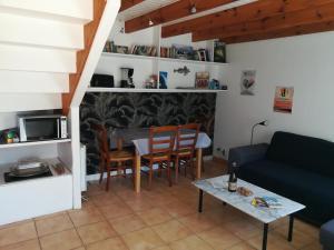 een woonkamer met een bank en een tafel bij Ty Biz in Saint-Jean-Trolimon