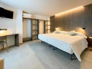 Postel nebo postele na pokoji v ubytování Hotel Quatre Llunes