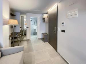a hallway with a door and a living room at Hotel Quatre Llunes in Santa Pola