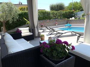 une terrasse avec un canapé et une piscine dans l'établissement A casa di Sabina, à Desenzano del Garda