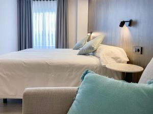 Postel nebo postele na pokoji v ubytování Hotel Quatre Llunes