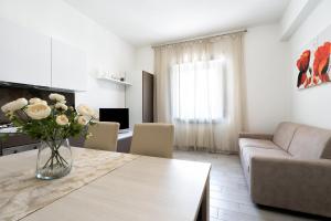 a living room with a vase of flowers on a table at Giselle Apartments Maiori - Amalfi Coast in Maiori