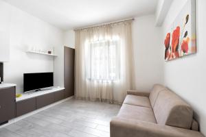 a living room with a couch and a television at Giselle Apartments Maiori - Amalfi Coast in Maiori