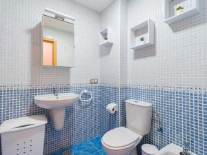 a blue tiled bathroom with a toilet and a sink at Mahostly La Casita de mi Rosita in Puerto del Rosario