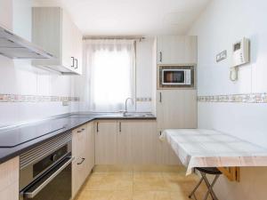 a white kitchen with a sink and a microwave at Mahostly La Casita de mi Rosita in Puerto del Rosario