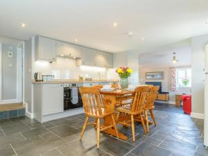 Golden Slack Cottage في Allgreave: مطبخ وغرفة طعام مع طاولة وكراسي